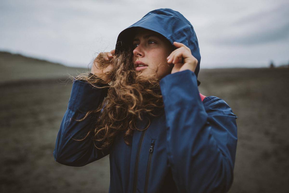 ilustrasi wanita memakai jaket windproof di gunung (freepik/wirestock)