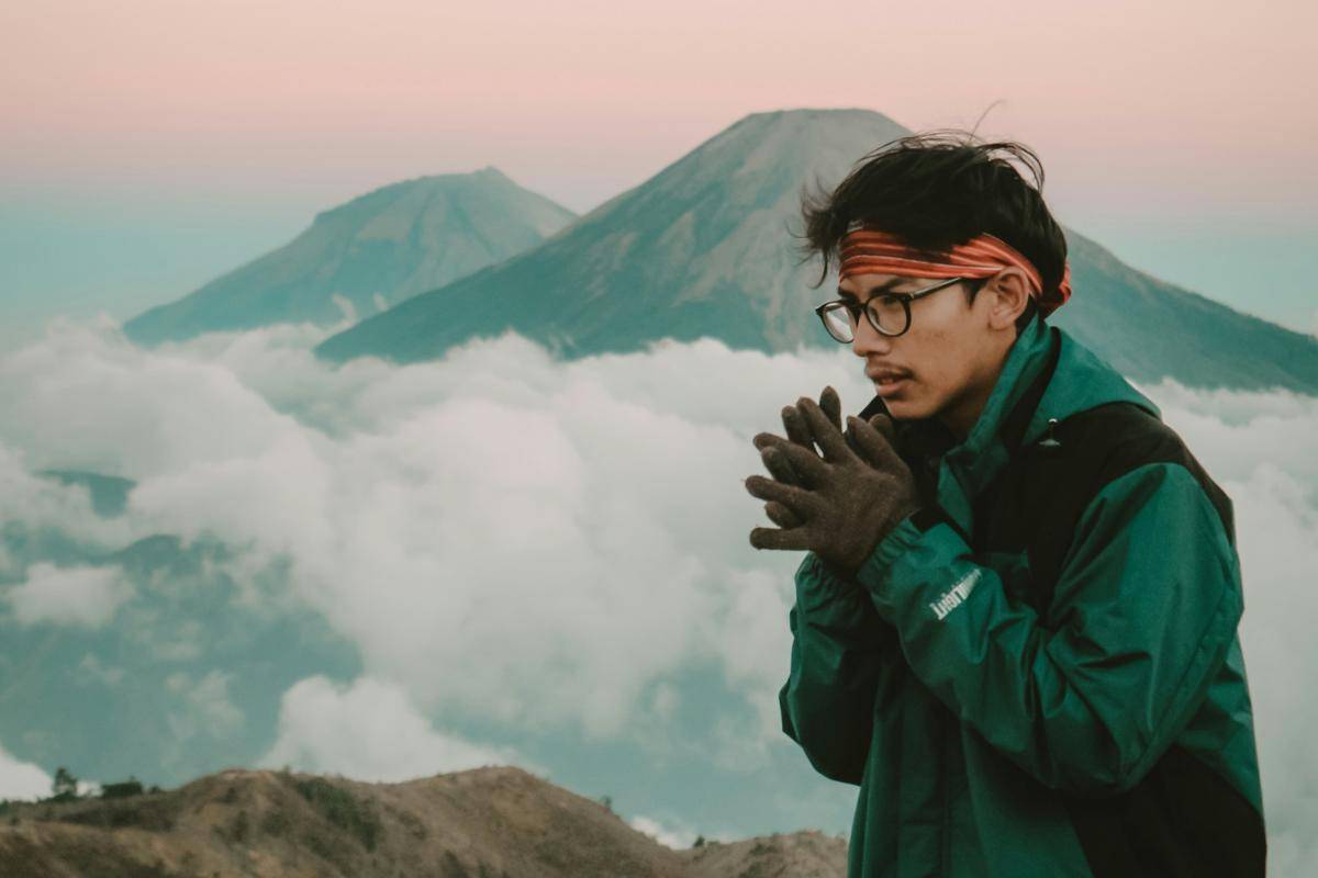 ilustrasi orang memakai sarung tangan saat mendaki gunung (unsplash/ Falaq Lazuardi)