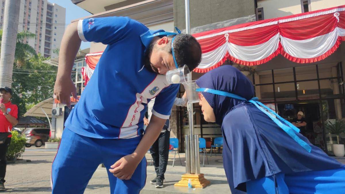 Lomba estafet bola menggunakan gelas di kepala (Dok. disperpusip.jatimprov)