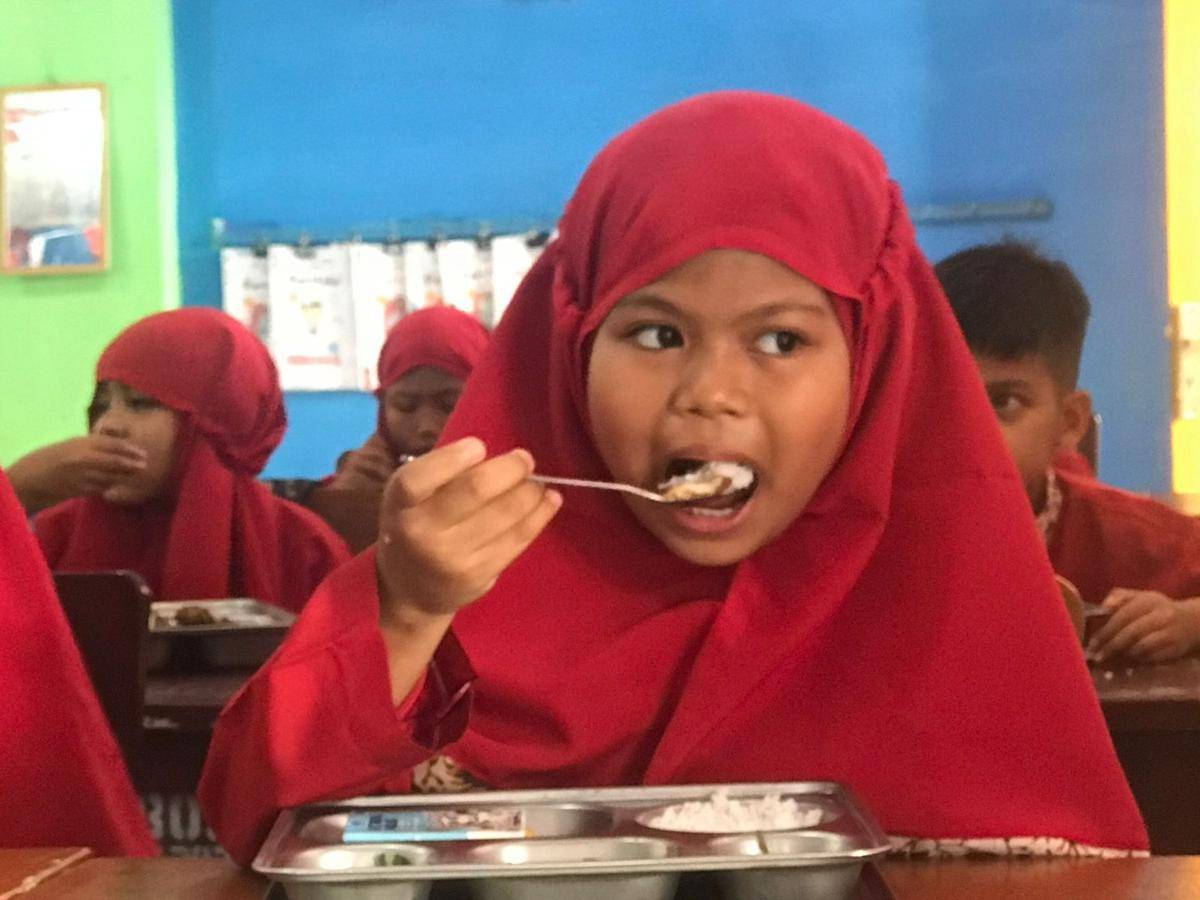 Seorang siswi di SDN 24 Padang menikmati MBG (Foto: IDN Times/Halbert Caniago)