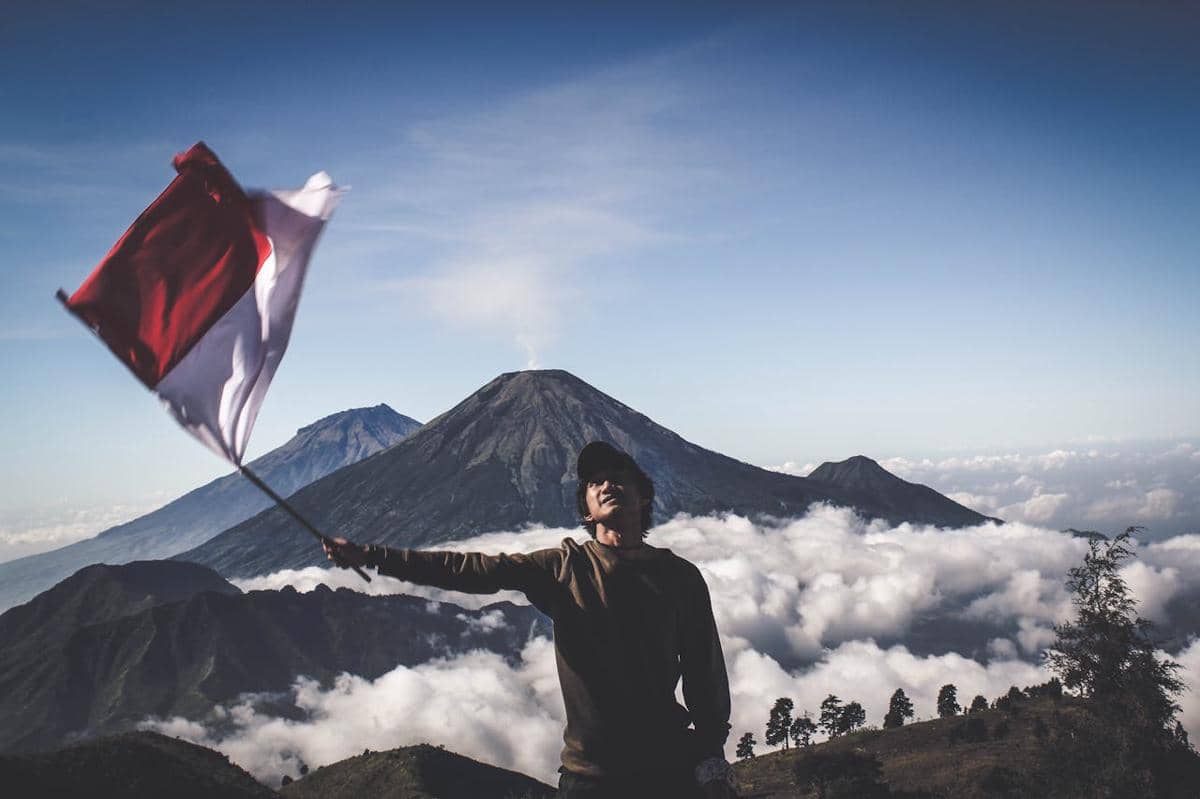 Potret mengibarkan bendera di gunung 