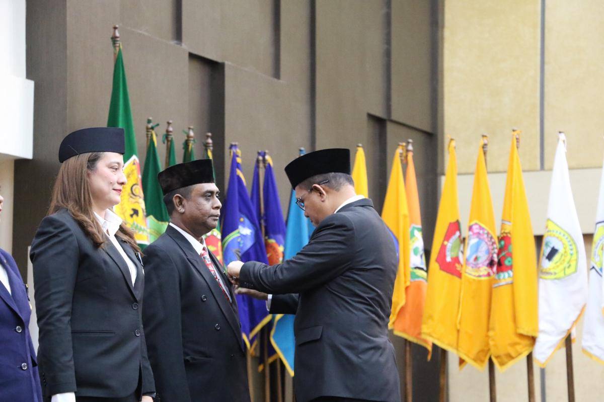 Seorang ASN usai mendapat lencana tanda jasa dari Gubernur NTT Melki Laka Lena. (Dok Humas Setda Provinsi NTT)