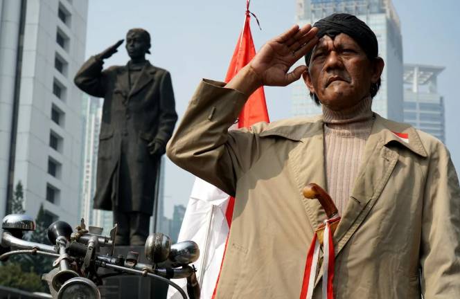 ilustrasi seorang pria hormat di dekat monumen nasional (pexels.com/salim-hanggara-purna)