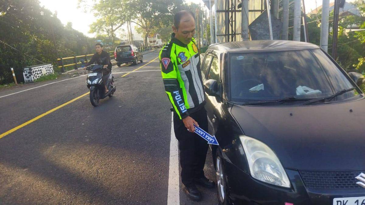 Petugas kepolisian melakukan olah tempat kejadian perkara di lokasi kecelakaan lalulintas di jalan utama Denpasar-Gilimanuk wilayah Kabupaten Jembrana, Pada Jumat (15/8/2025).