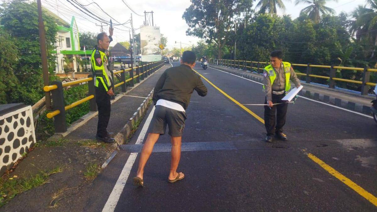 Petugas kepolisian melakukan olah tempat kejadian perkara di lokasi kecelakaan lalulintas di jalan utama Denpasar-Gilimanuk wilayah Kabupaten Jembrana, Pada Jumat (15/8/2025).