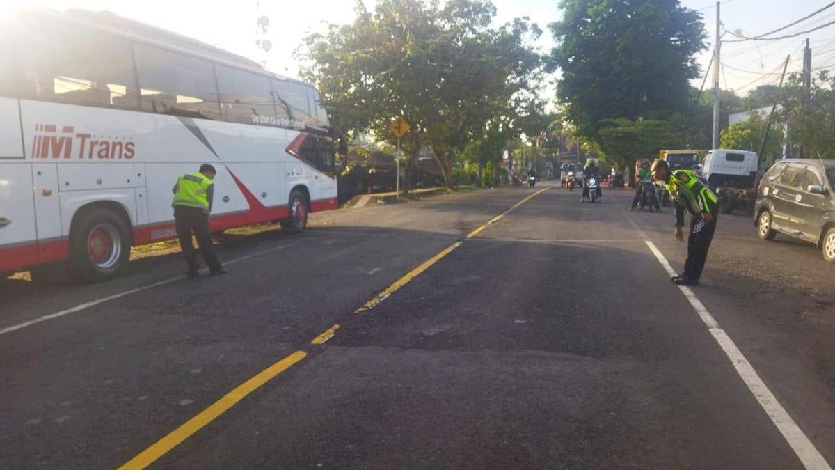 Petugas kepolisian melakukan olah tempat kejadian perkara di lokasi kecelakaan lalulintas di jalan utama Denpasar-Gilimanuk wilayah Kabupaten Jembrana, Pada Jumat (15/8/2025).