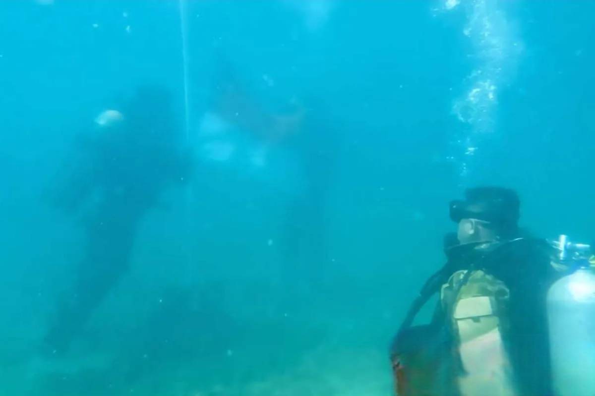 Prajurit Komando Daerah Militer Angkatan Laut VI saat melakukan pengibaran bendera merah putih di bawah laut di Pulau Barrang, Kota Makassar. (ANTARA FOTO/Kodaeral VI)
