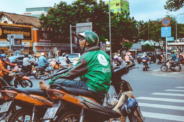 Driver ojek Vietnam sedang duduk di motornya. (pexels.com/Lê Quốc Hùng)