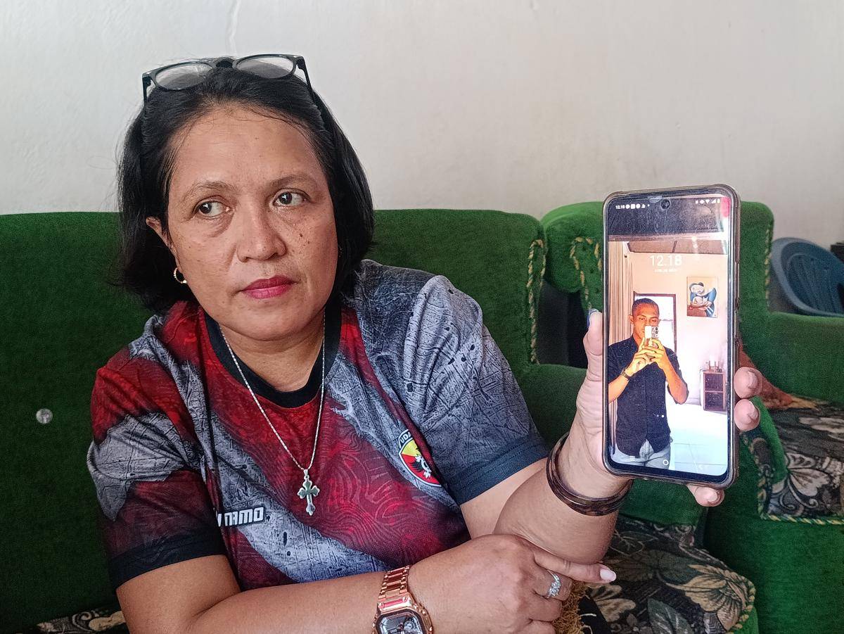Ibunda Prada Lucky menunjukkan handphone milik anaknya yang tewas dianiaya. (IDN Times/Putra Bali Mula)