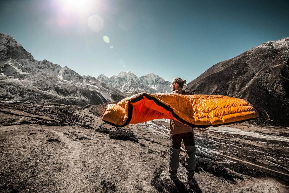 ilustrasi pria membawa sleeping bag (unsplash.com/Martin Jernberg)