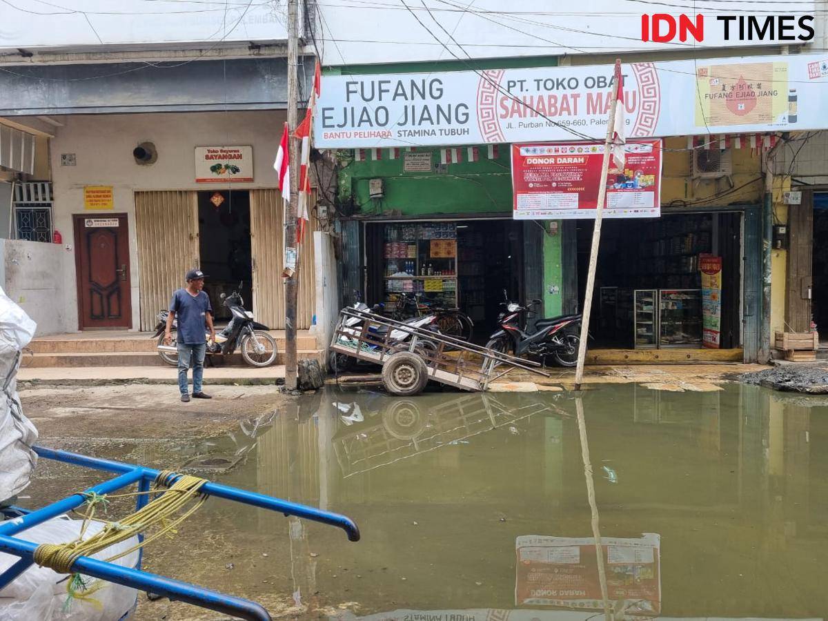 Kondisi jalan Purban Komplek Pertokoan 16 Ilir Palembang tergenang air akibat drainase yang tidak berjalan.