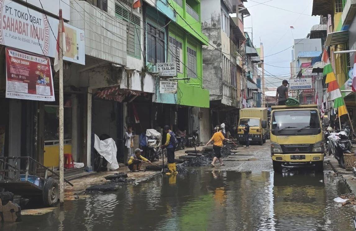 Aksi protes warga di komplek Pertokoan 16 Ilir Palembang akibat genangan air yang terjadi satu bulan terakhir (Instagram: @Susantokomah)