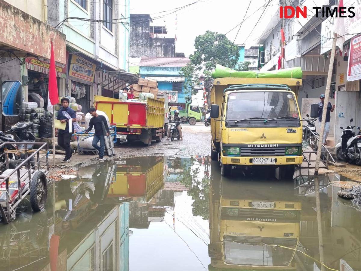 Kondisi jalan Purban Komplek Pertokoan 16 Ilir Palembang tergenang air akibat drainase yang tidak berjalan.