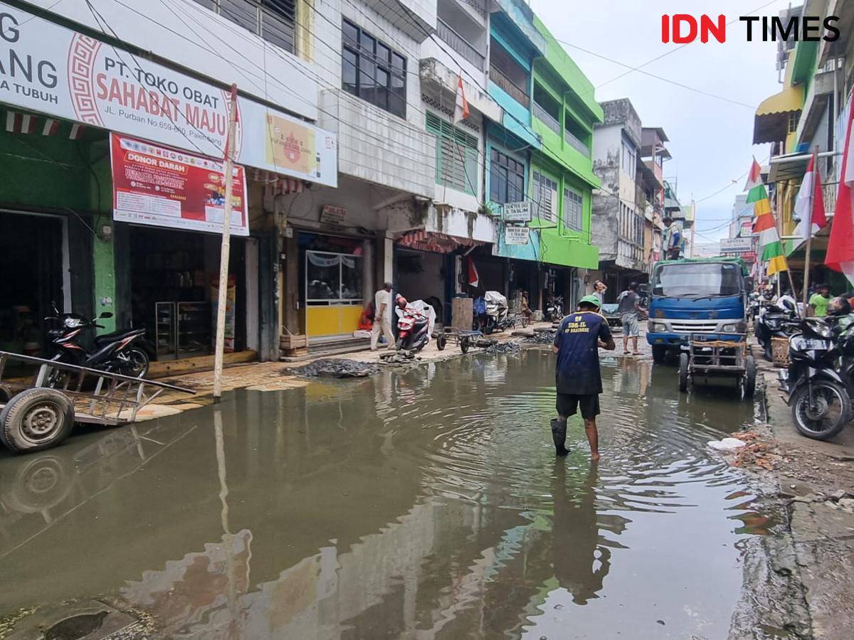 Kondisi jalan Purban Komplek Pertokoan 16 Ilir Palembang tergenang air akibat drainase yang tidak berjalan.