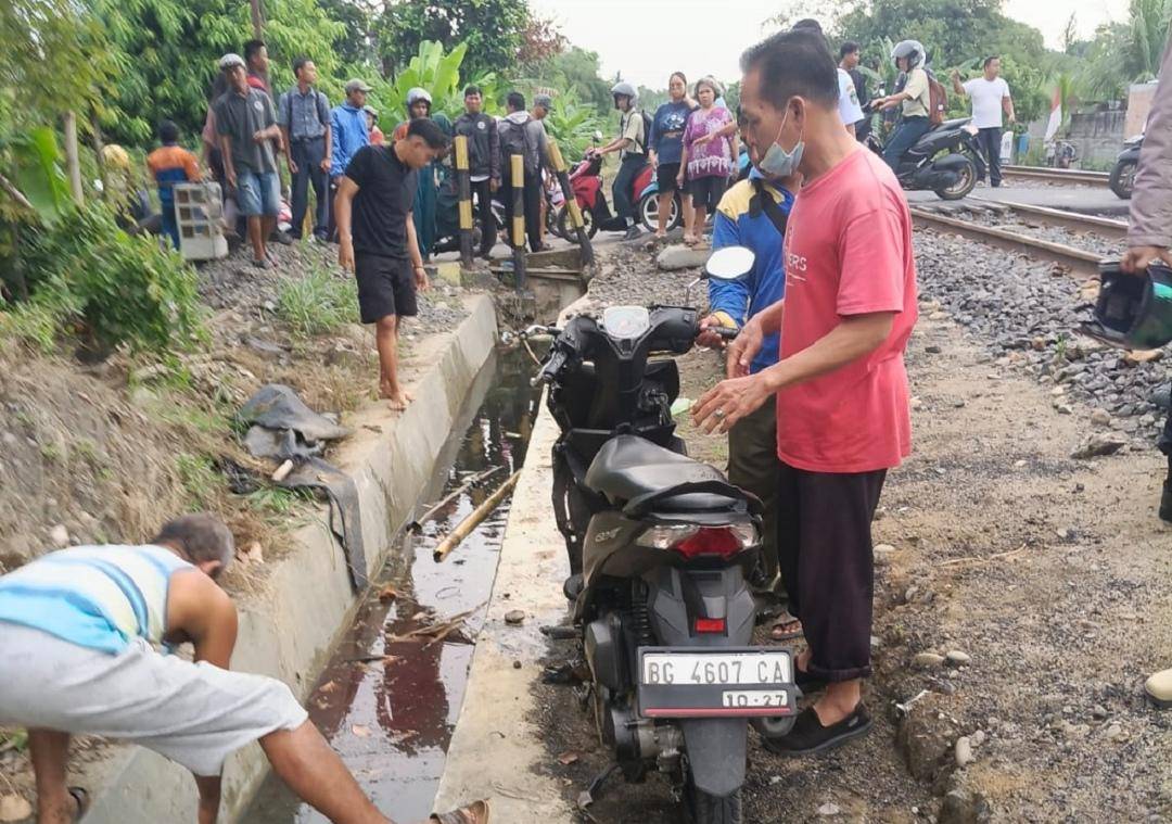 Warga mengevakuasi remaja yang tertangkap kereta api di Prabumulih. (Dok. Istimewa)