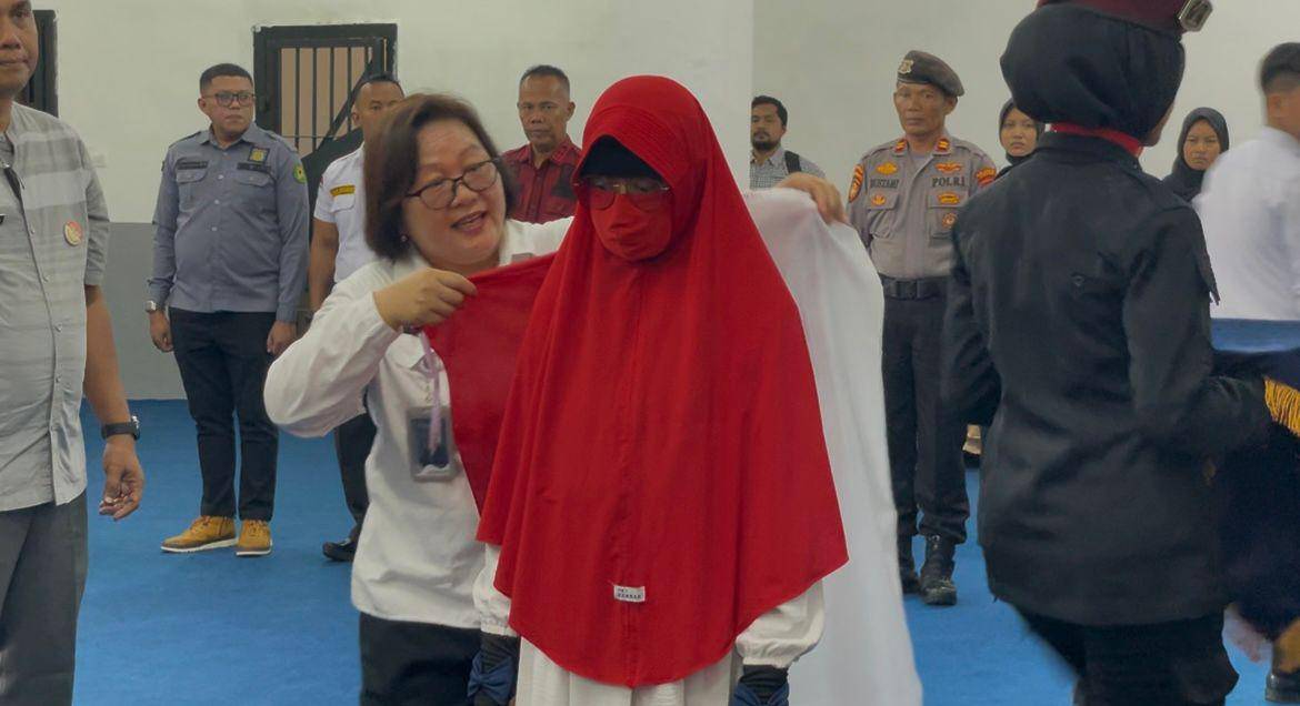 Kalapas Perempuan Padang mengenakkan bendera merah putih ke punggung Yuliati (Foto: IDN Times/Halbert Caniago)