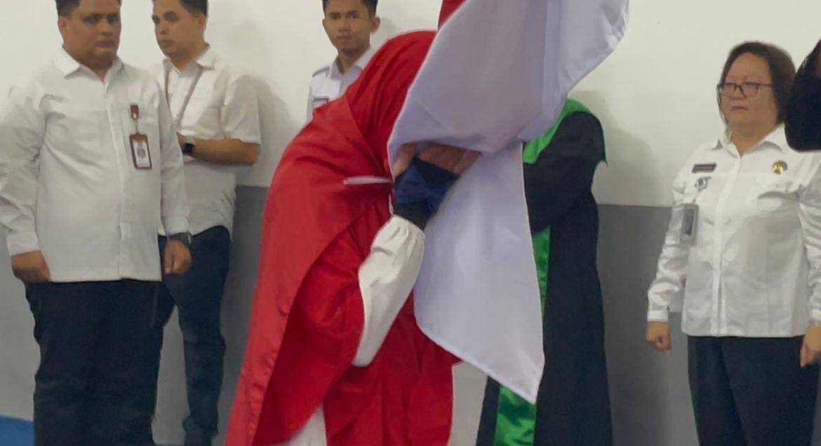 Yuliati mencium bendera merah putih diiringi dengan lagu Padamu Negeri (Foto: IDN Times/Halbert Caniago)