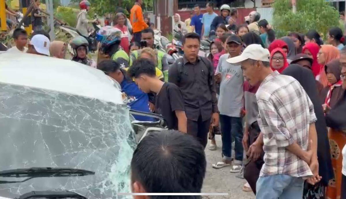 warga melihat keadaan mobil yang tertabrak kereta api (Foto: Istimewa)