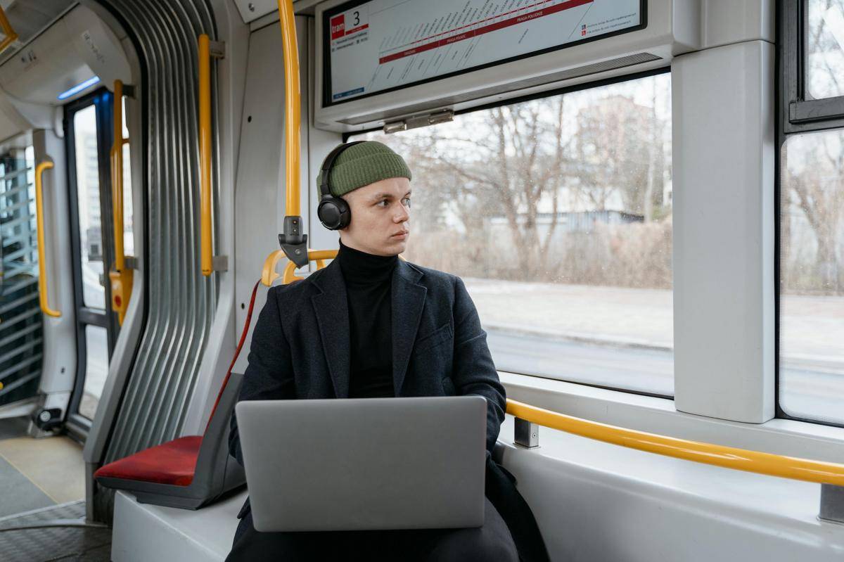 ilustrasi pria menggunakan laptop di kereta (pexels.com/Mart Production)