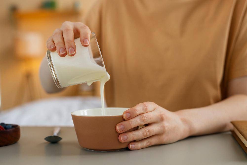 Potret orang menuangkan segelas susu