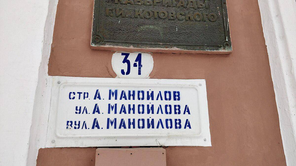 potret papan tanda jalan dalam bahasa Rumania, Rusia, dan Ukraina dengan aksara Sirilik (dari atas ke bawah) di Tiraspol 