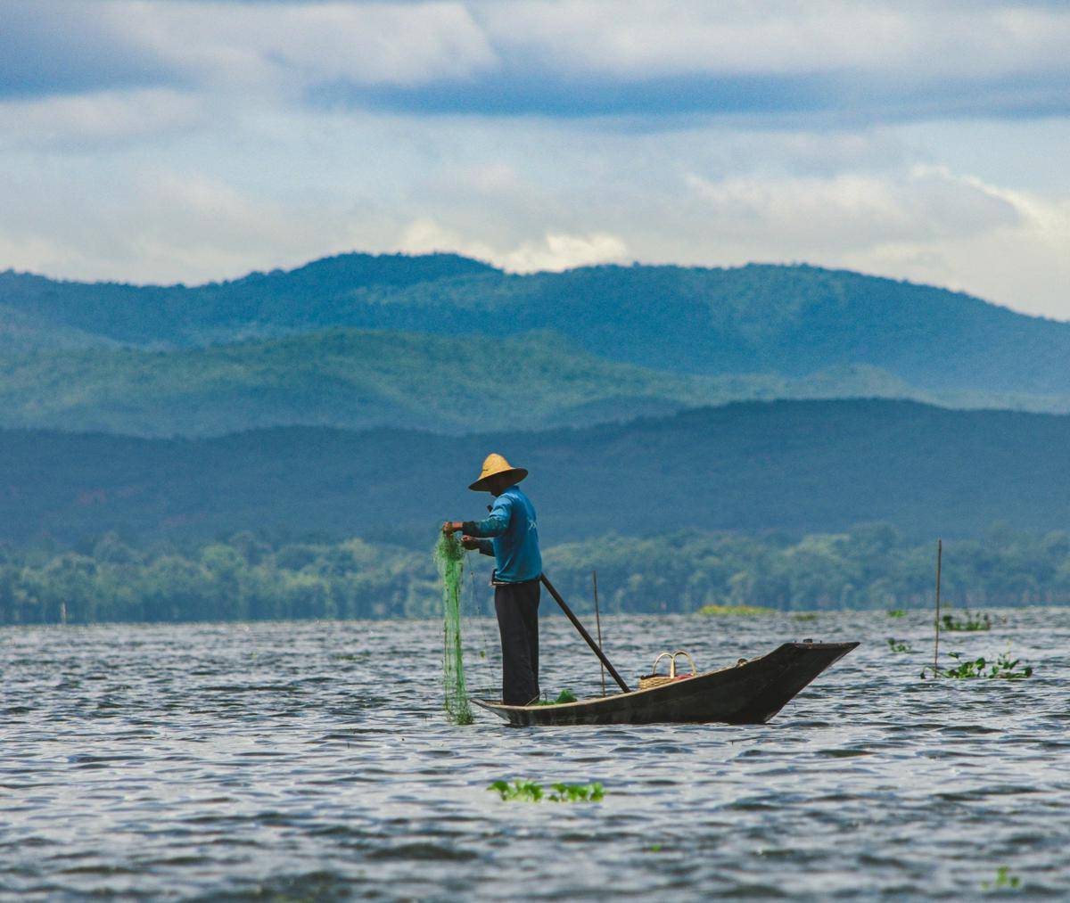 gambar seorang nelayan di sedang menangkap ikan (unsplash.com/Zinko Hein)