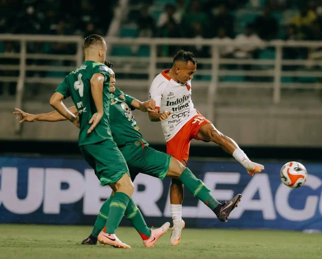 Irfan Jaya (putih) saat berebut bola dengan pemain Persebaya Surabaya (hijau). (Instagram.com/baliunitedfc)