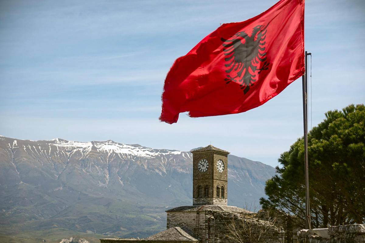 potret bendera Albania dan benteng Gjirokastër di belakangnya