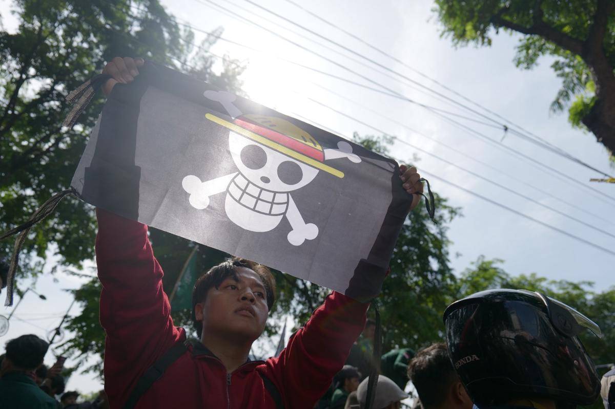 Massa aksi di DPRD Sumut membawa bendera One Piece saat unjuk rasa, Selasa (26/8/2025) (IDN Times/Prayugo Utomo)