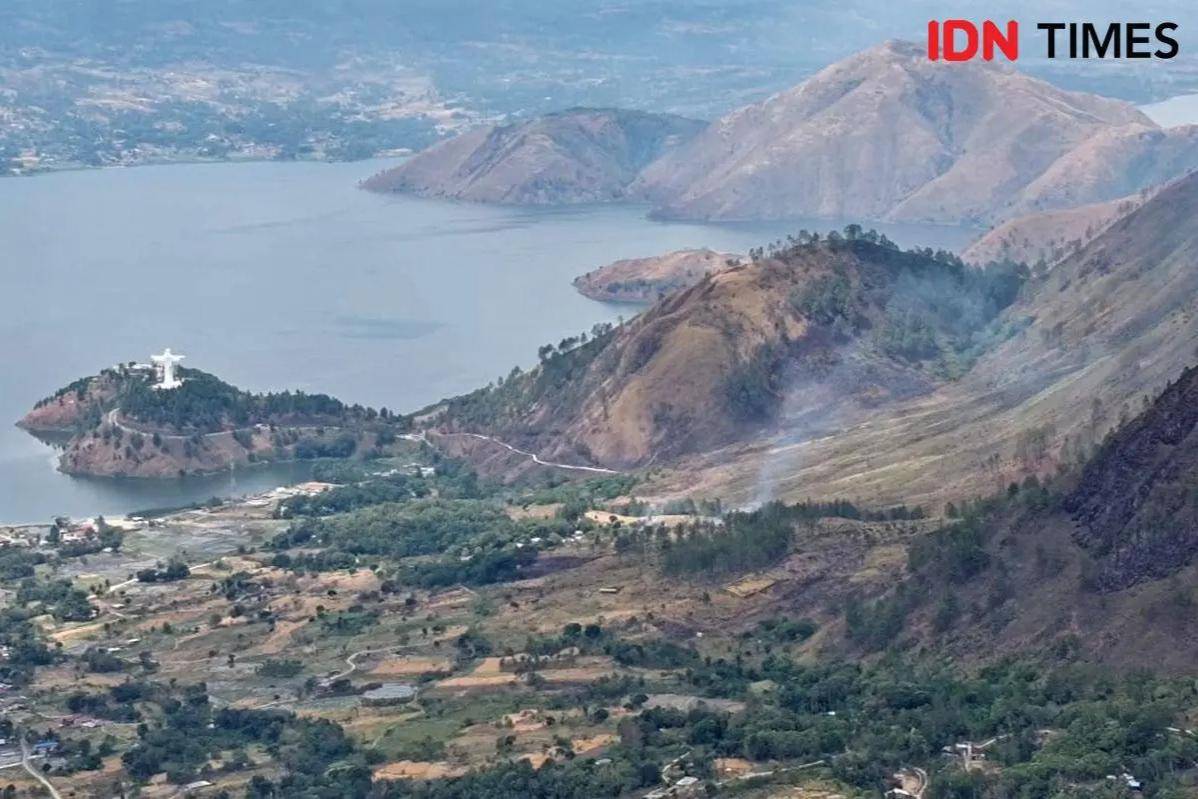 Bukit di Samosir sudah gundul akibat Karhutla, bahkan beberapa titik masih terlihat terbakar dari kawasan Tele, Jumat (25/7/2025). (IDN Times/Arifin Al Alamudi)