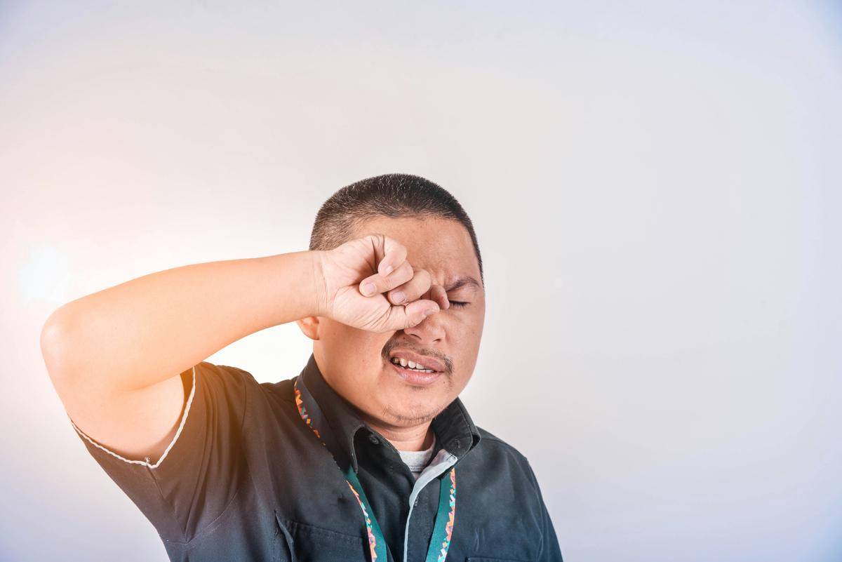 Seorang laki-laki mengucek matanya.