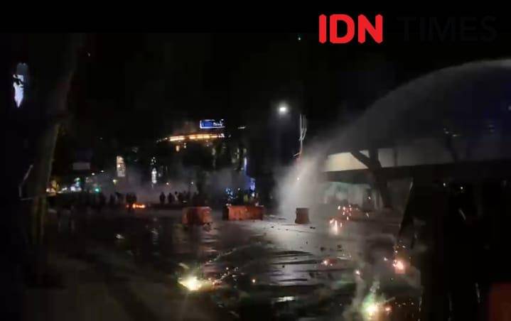 Aparat menembbak meriam air ke arah massa aksi di Jalan Panglima Soedirman, Surabaya.