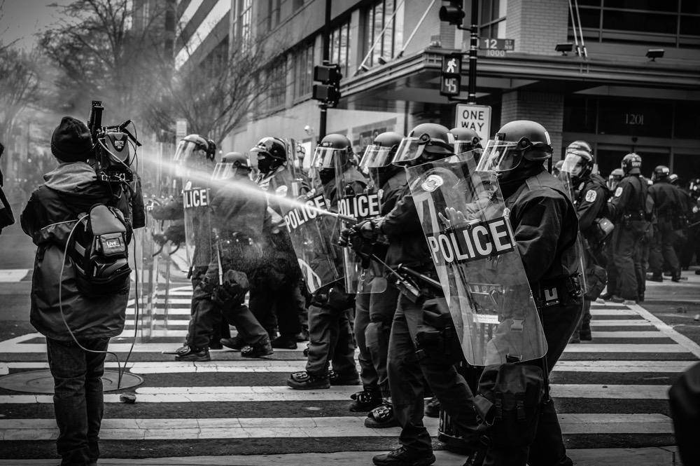 gambar sekelompok polisi menembakkan gas air mata (unsplash.com/Spenser H)