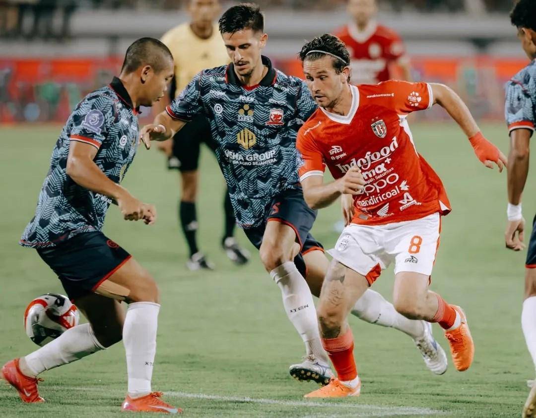 Jordy Bruijn (merah) diapit pemain Madura United. (Instagram.com/baliunitedfc)