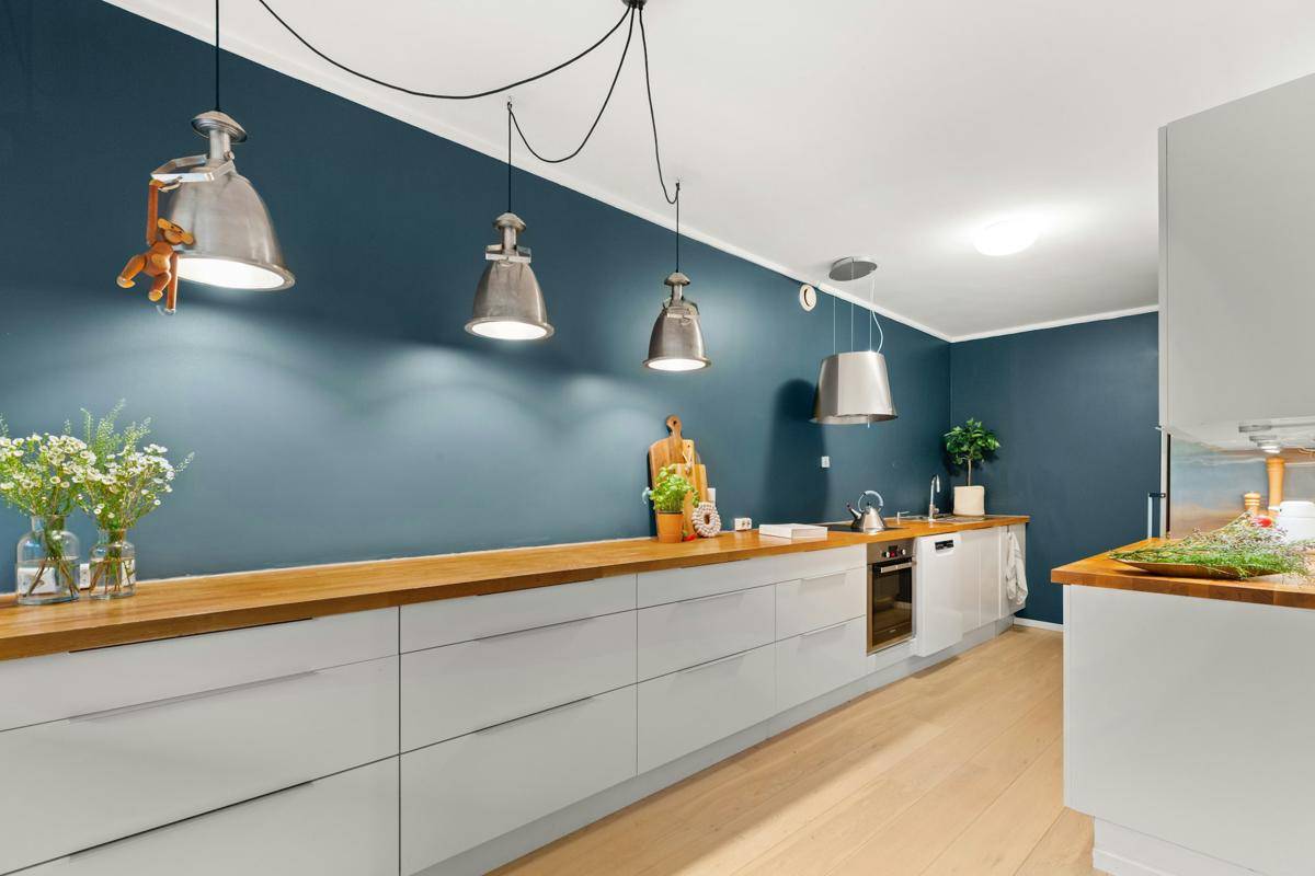 Dapur warna biru navy dipadukan dengan furnitur kayu berwarna terang. (Unplash.com/Lisa Anna)