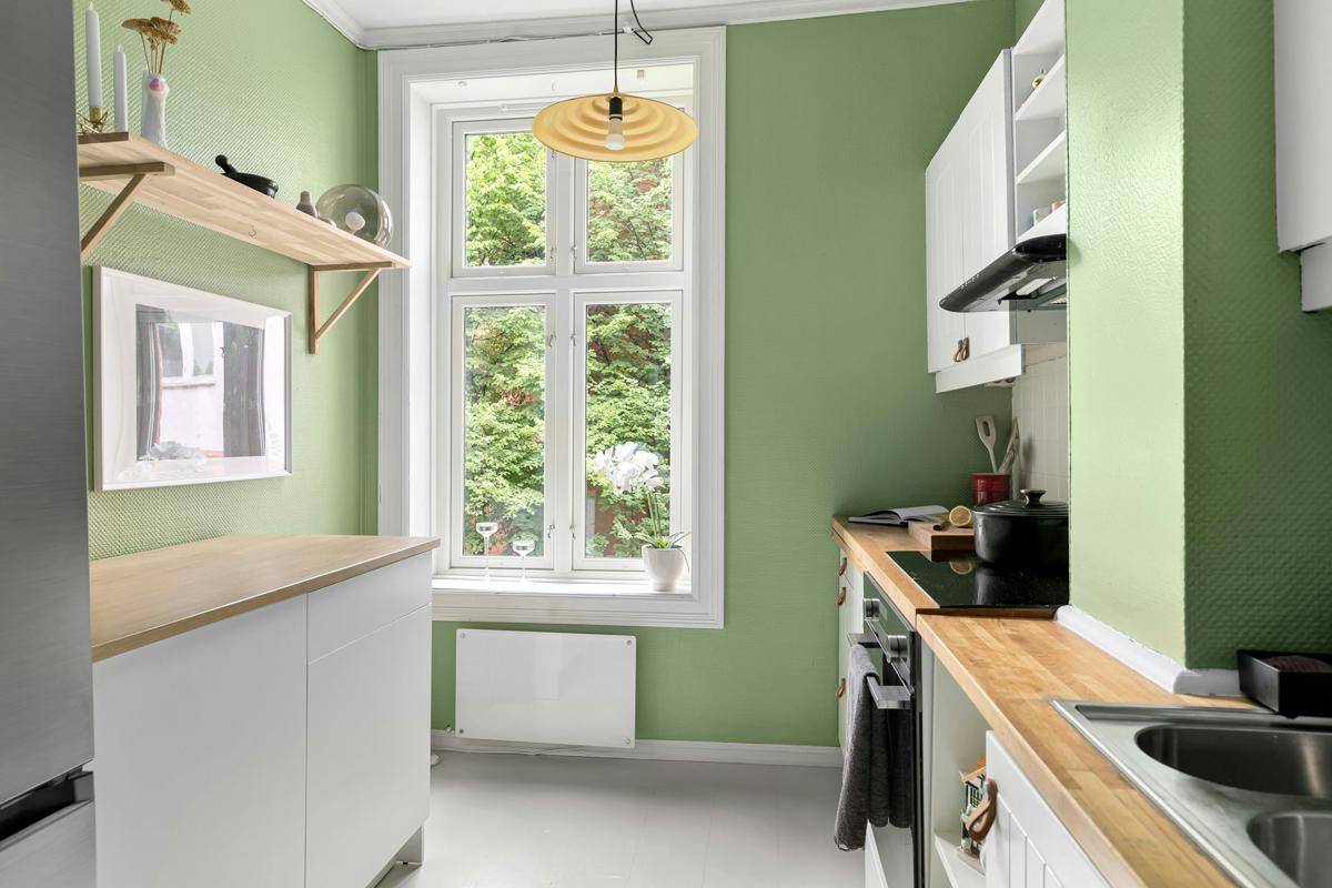Dapur warna hijau sage dipadukan dengan furnitur kayu berwarna terang. (Unplash.com/Lisa Anna)