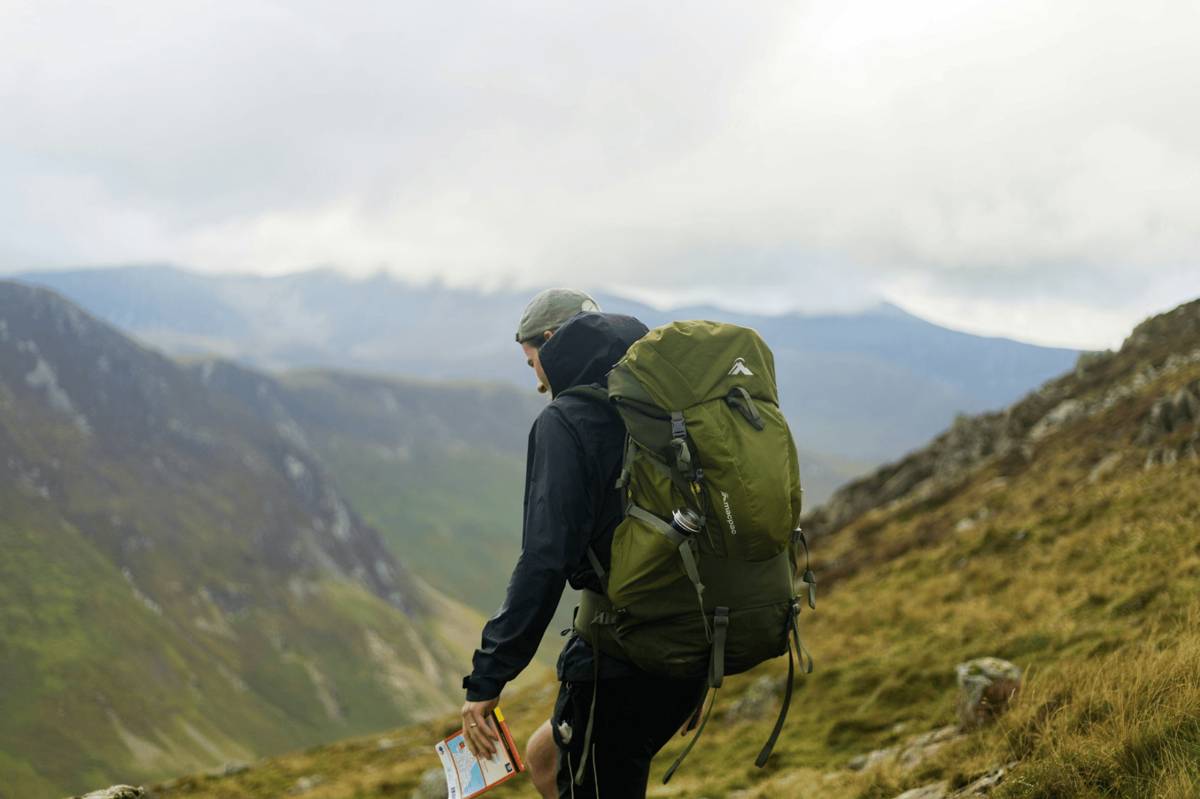 ilustrasi pria menggunakan carrier di gunung (unsplash.com/spencerecclesjones)