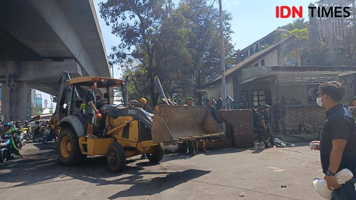 Kendaraan berat dikerahkan untuk membersihkan sisa material pasca kebakaran Gedung DPRD Makassar, Sabtu (30/8/2025) pagi. (IDN Times/Asrhawi Muin)