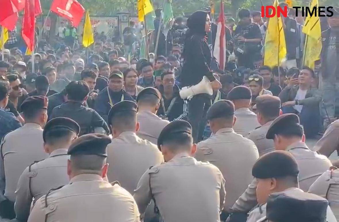 Saat aparat kepolisian duduk bersila dengan demonstran.