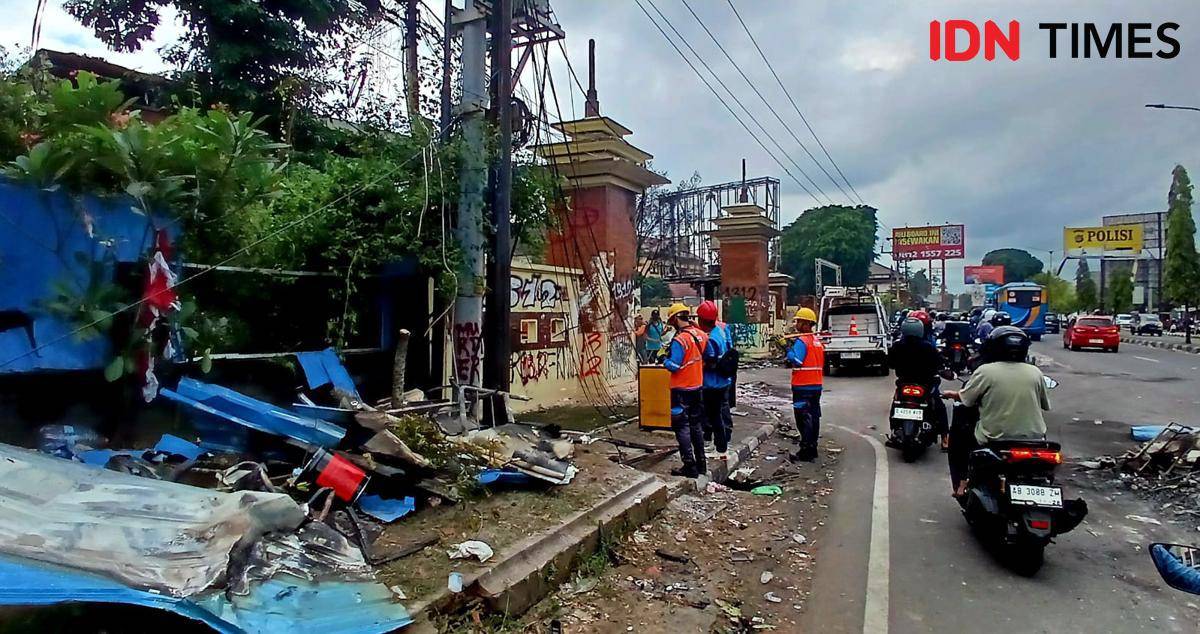 Petugas Dinas Lingkungan Hidup (DLH) membersihkan sisa sampah. 