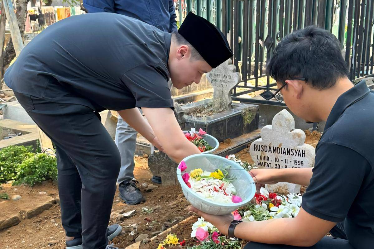 Halim Wijaya, Director of East Operations, Grab Indonesia (kiri) menaburkan bunga ketika berziarah ke makam mendiang Rusdamdiansyah (Dandi), Mitra Pengemudi Grab yang meninggal dunia dalam insiden aksi unjuk rasa di Makassar. (Dok. Istimewa)