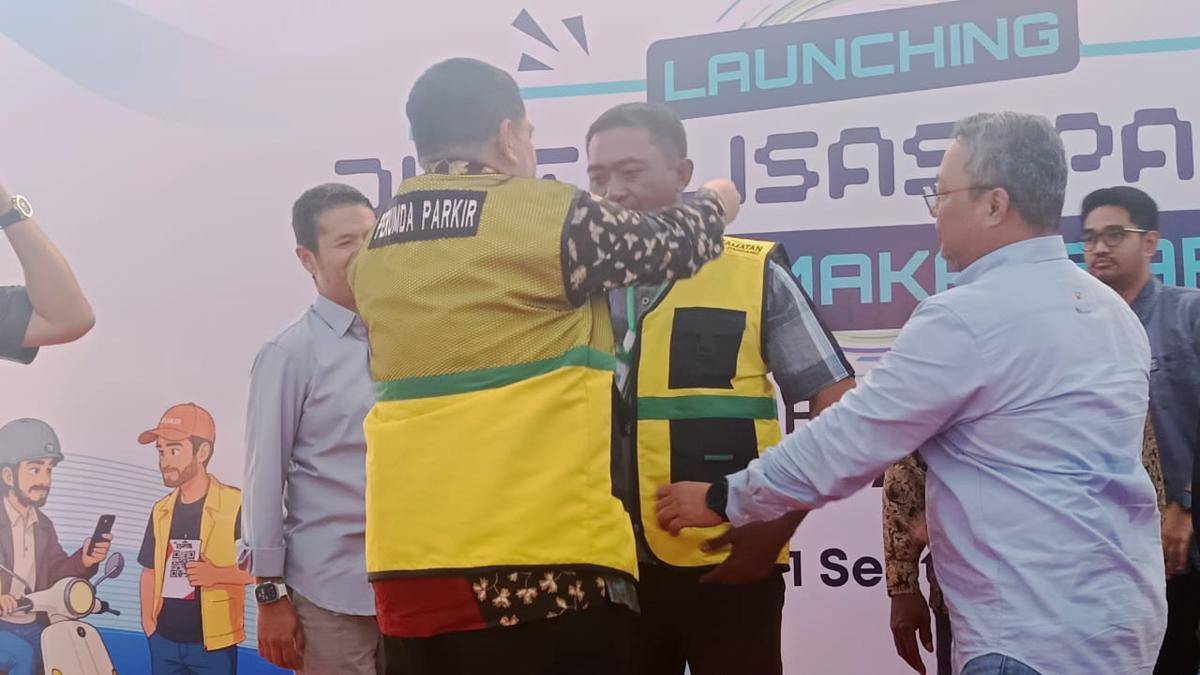 Wali Kota Makassar Munafri Arifuddin memasangkan kalung lanyard QRIS card kepada perwakilan juru parkir saat peluncuran digitalisasi parkir di Kota Makassar, Senin (1/9/2025). (IDN Times/Asrhawi Muin)