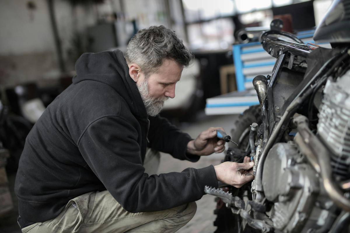 pria yang sedang servis motor