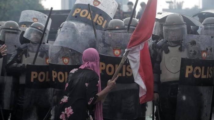 Ibu berjilbab pink pada aksi di depan DPR mengahadang aparat (CNN Indonesia/Adhi Wicaksono)