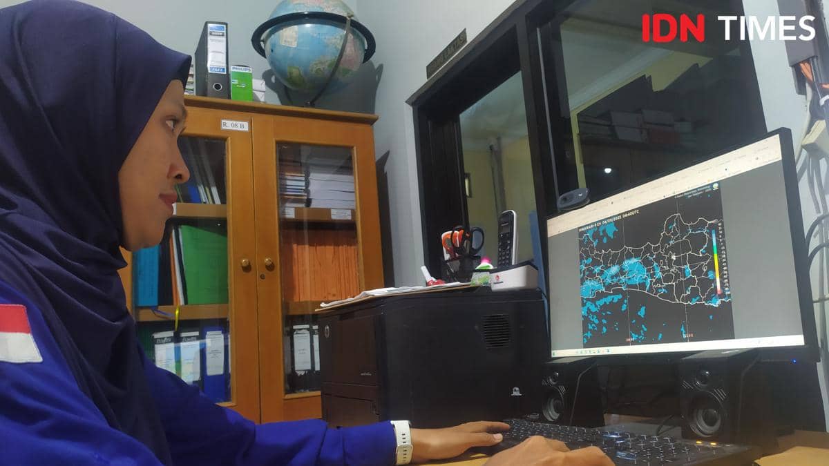 Seorang prakirawan cuaca Stasiun BMKG Meteorologi Ahmad Yani Semarang Noor Jannah mengecek arah angin dari layar monitor komputer yang terhubung dengan citra satelit BMKG. (IDN Times/Fariz Fardianto)
