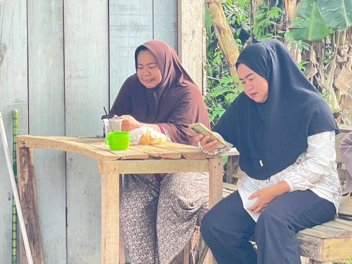 Warga Langki menggunakan internet di depan rumahnya (Foto: IDN Times/Halbert Caniago)
