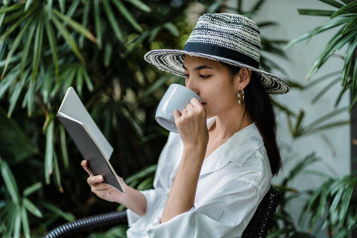 ilustrasi wanita sedang menikmati minuman sambil membaca buku. (pexels.com/Armin Rimoldi)