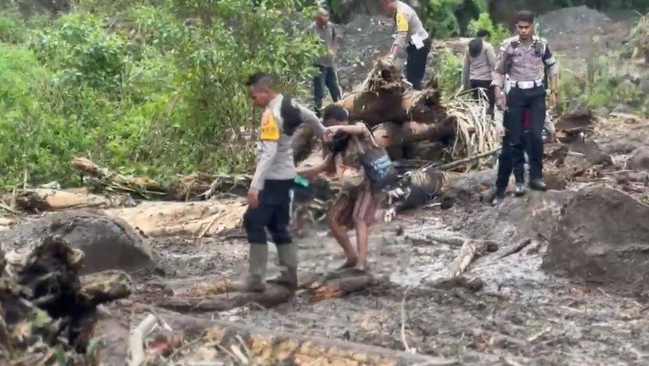 Polisi membantu warga melintasi jalur pasca longsor dan banjir di Nagekeo, NTT. (Dok Humas Polres Nagekeo)