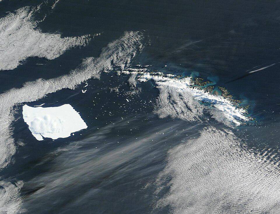 Citra satelit dari Gunung Es A23a (kiri) tertahan di dekat Pulau Georgia Selatan (kanan) pada Maret 2025.