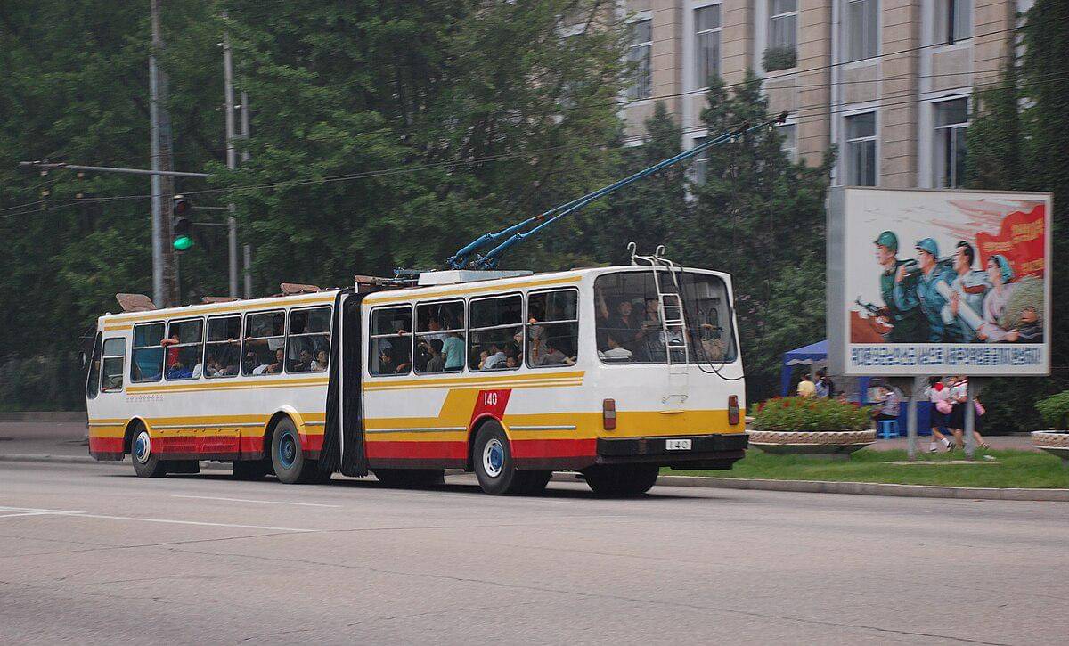potret bus troli gandeng Pyongyang No. 140 berwarna putih, kuning, dan merah